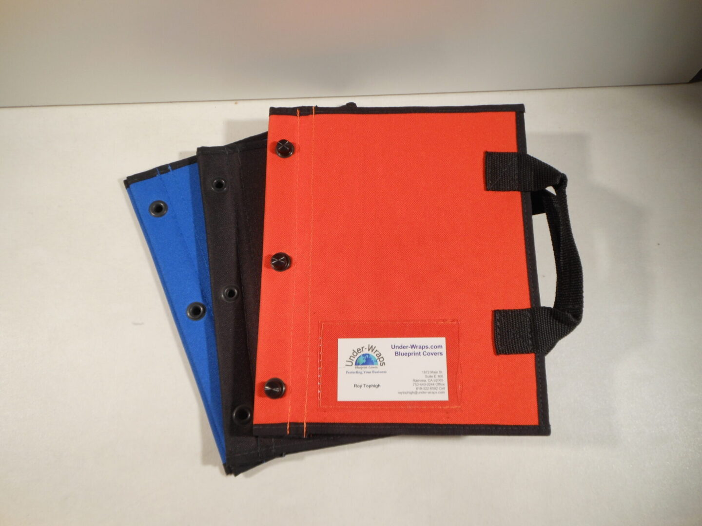 Three notebooks with a handle and two of them are orange.